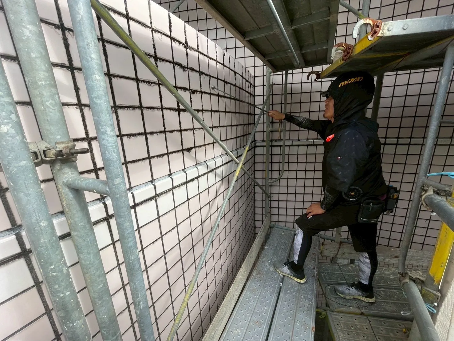 作業員が外壁改修工事をしているところ